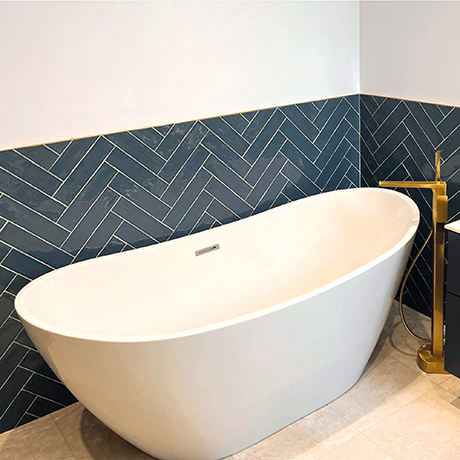 Freestanding bath featuring Poitiers Indigo on the wall in a herringbone layout