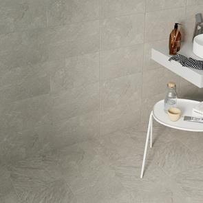 Matching wall and floor tiles in a bathroom setting with white furnishings