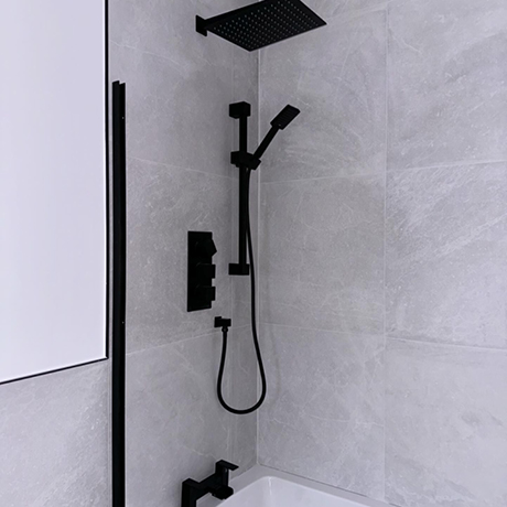 White wall tiles in bathroom with black accessories